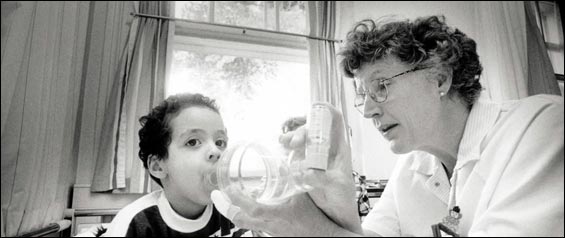 In this undate image a child is helped with an asthma inhaler.
